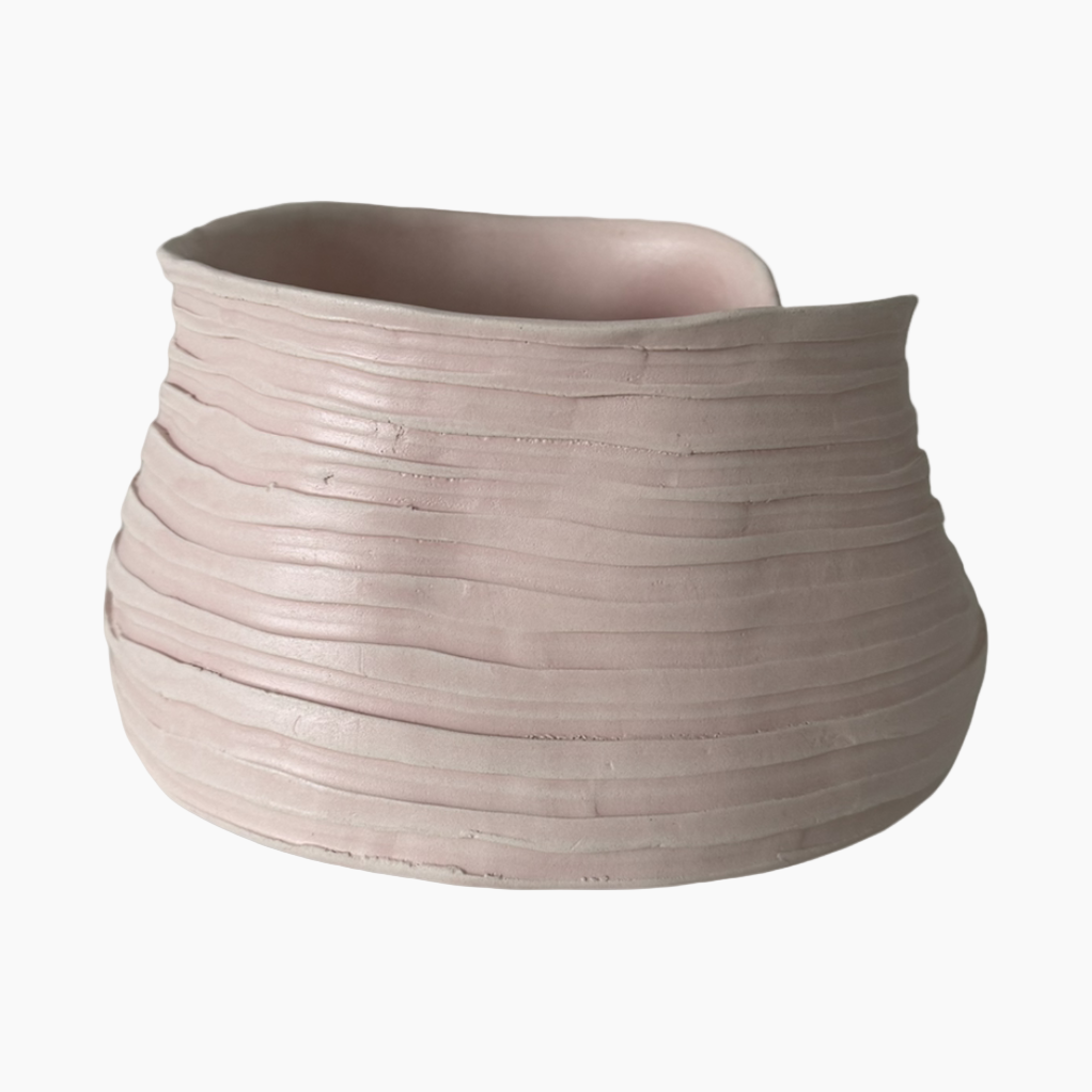 Ceramic vase with ribbed texture on a white background