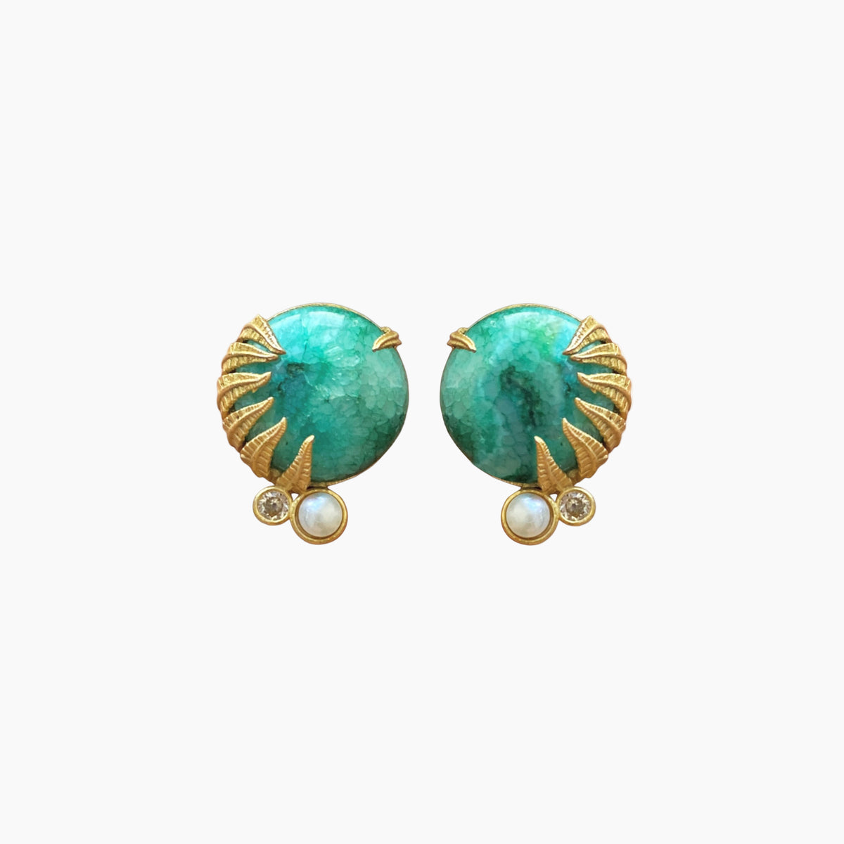 Pair of earrings with green gemstones and gold accents on a white background