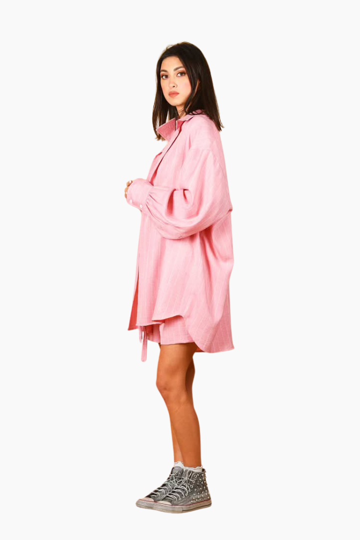 Woman wearing a pink dress with a white background