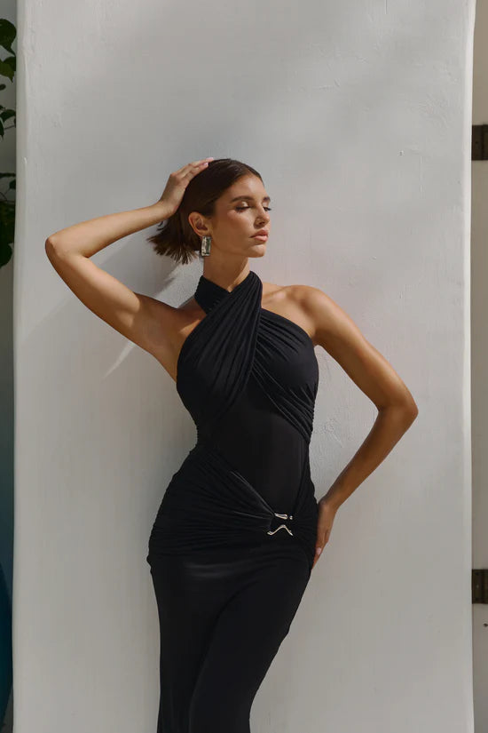 Woman wearing a black halter neck dress.
