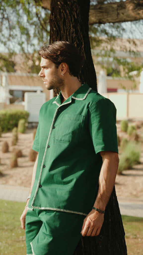 Man wearing a green outfit standing outdoors