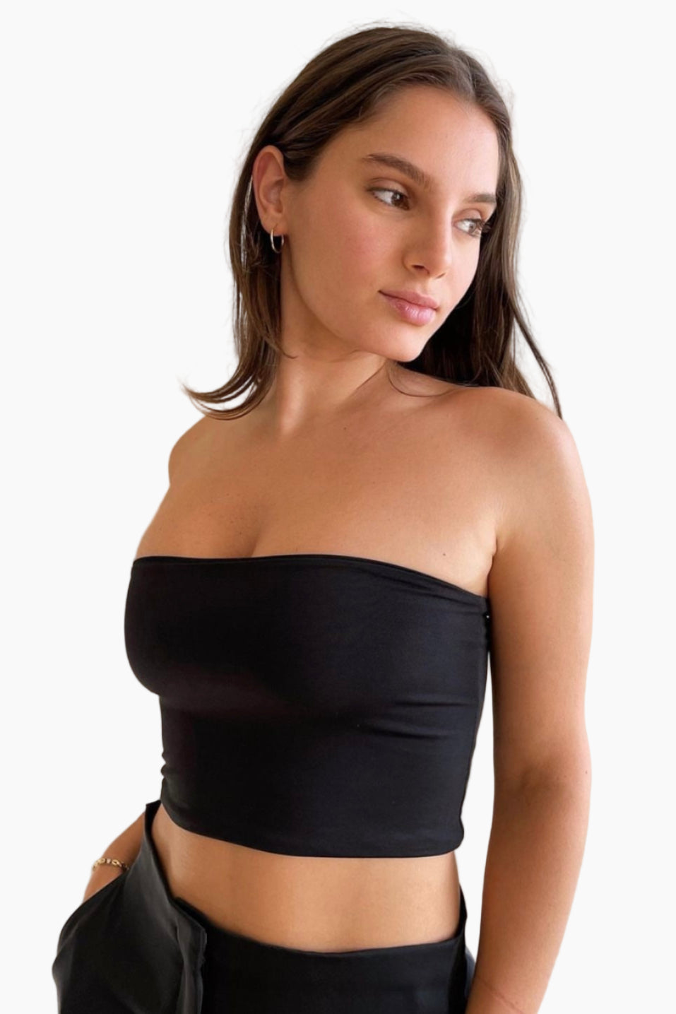 Woman wearing a black strapless top against a white background