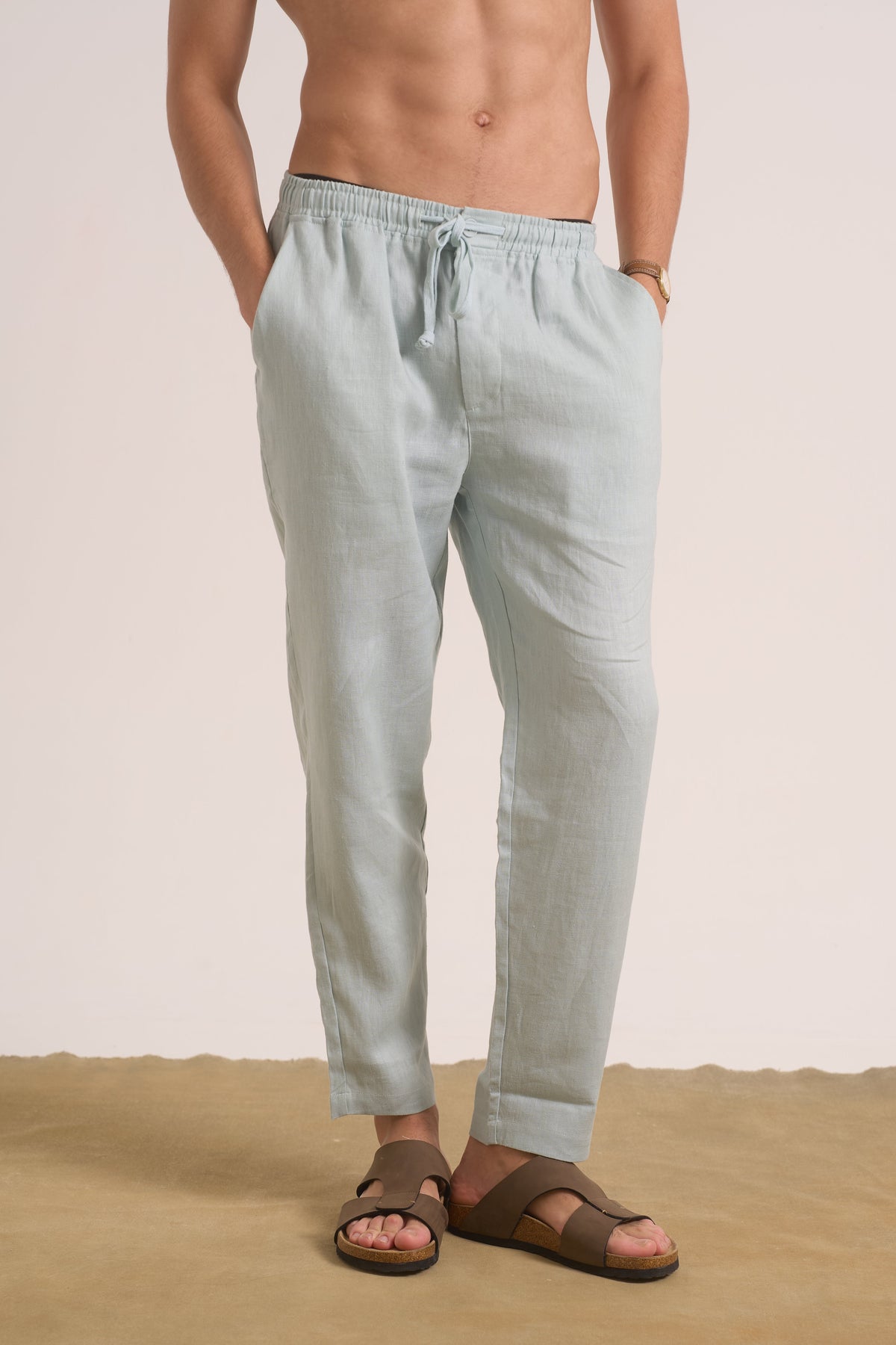 Person wearing light gray pants and brown sandals