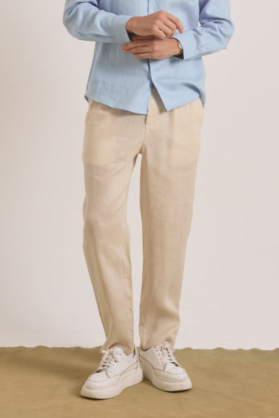 Person wearing a light blue shirt, beige pants, and white sneakers .