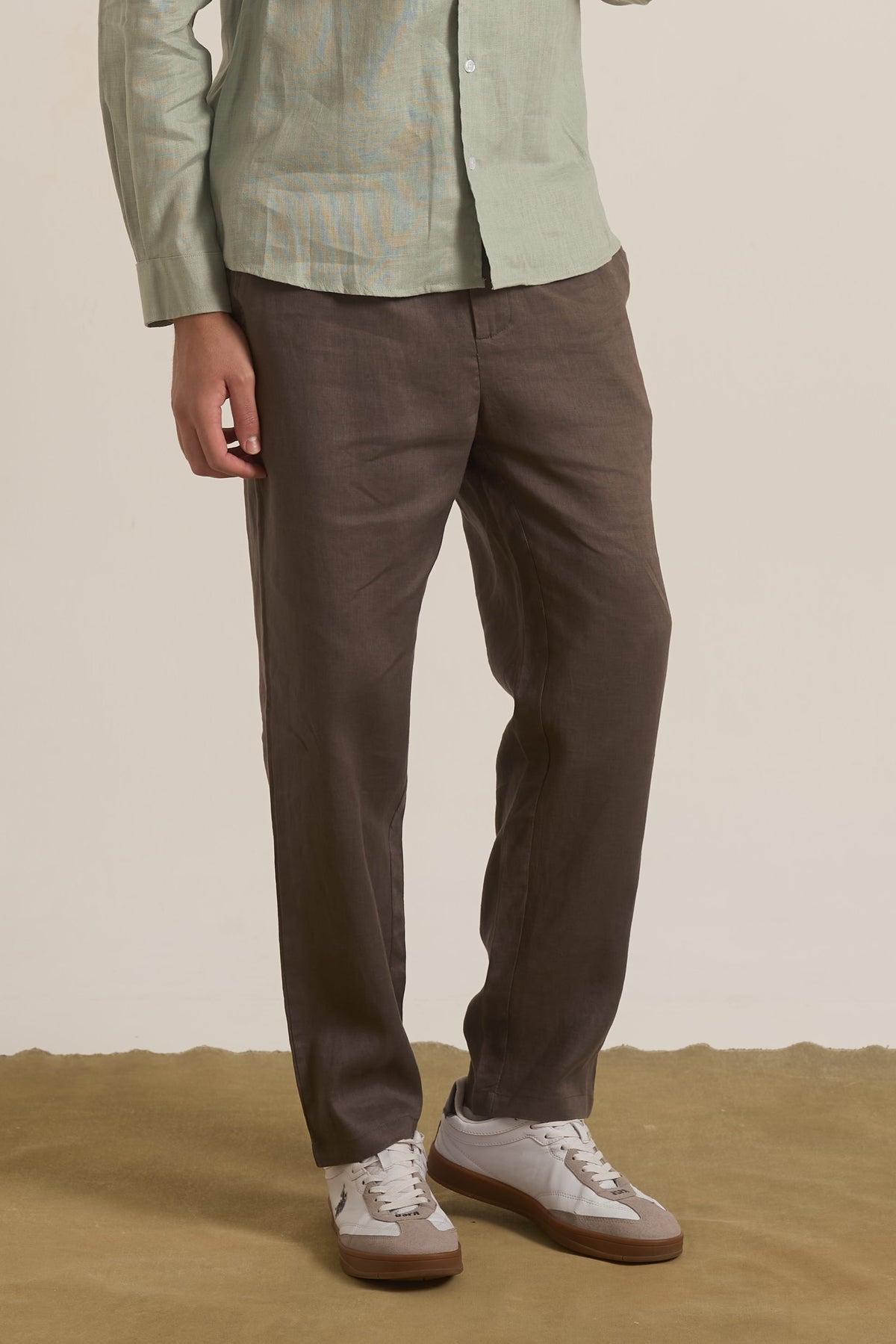 Person wearing a green jacket and brown pants