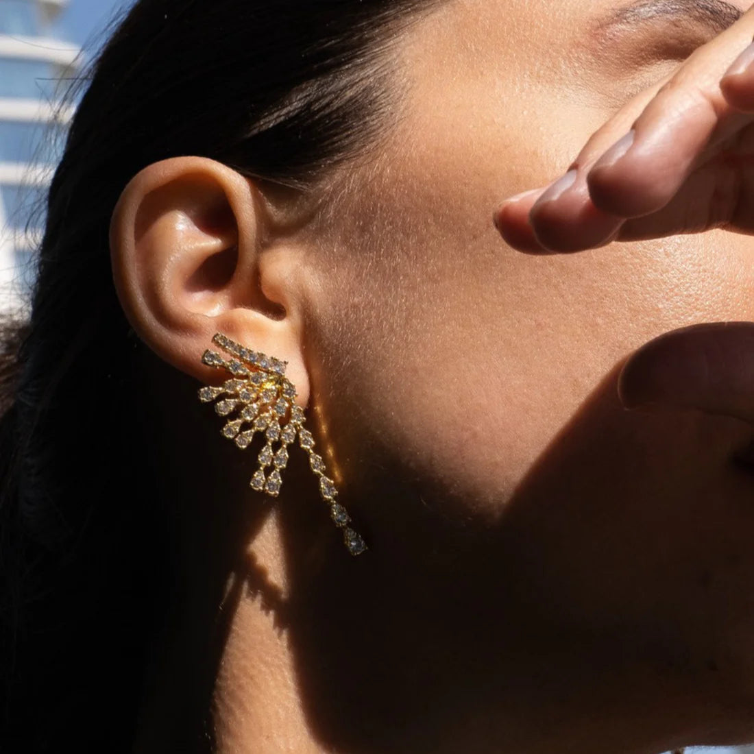 Close-up of an ear wearing a sparkling earring with a blurred background