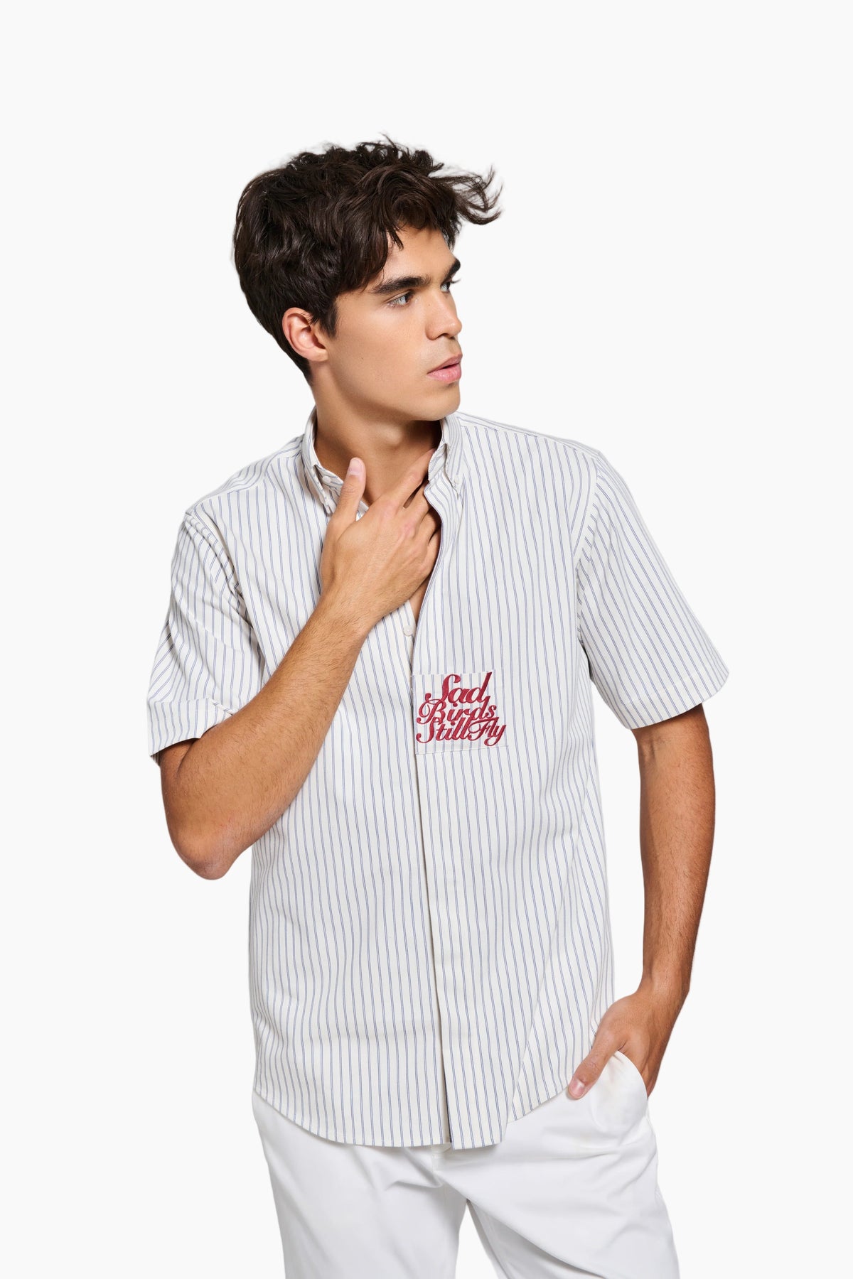 Person wearing a white striped shirt with red text on a light gray background