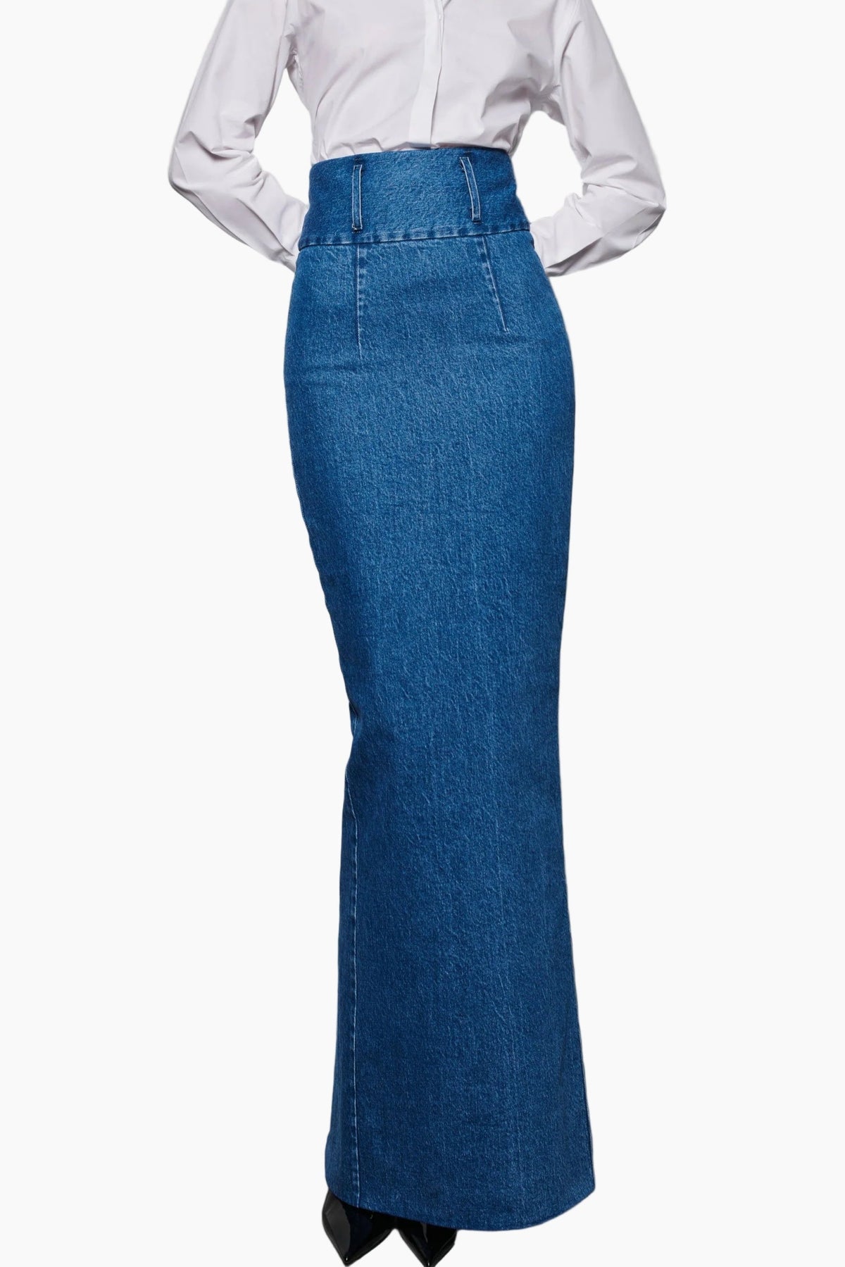 Woman wearing a white blouse with high waist indigo jeans fit to waist skirt with stretch cotton fabric, detailed with two belt loops.