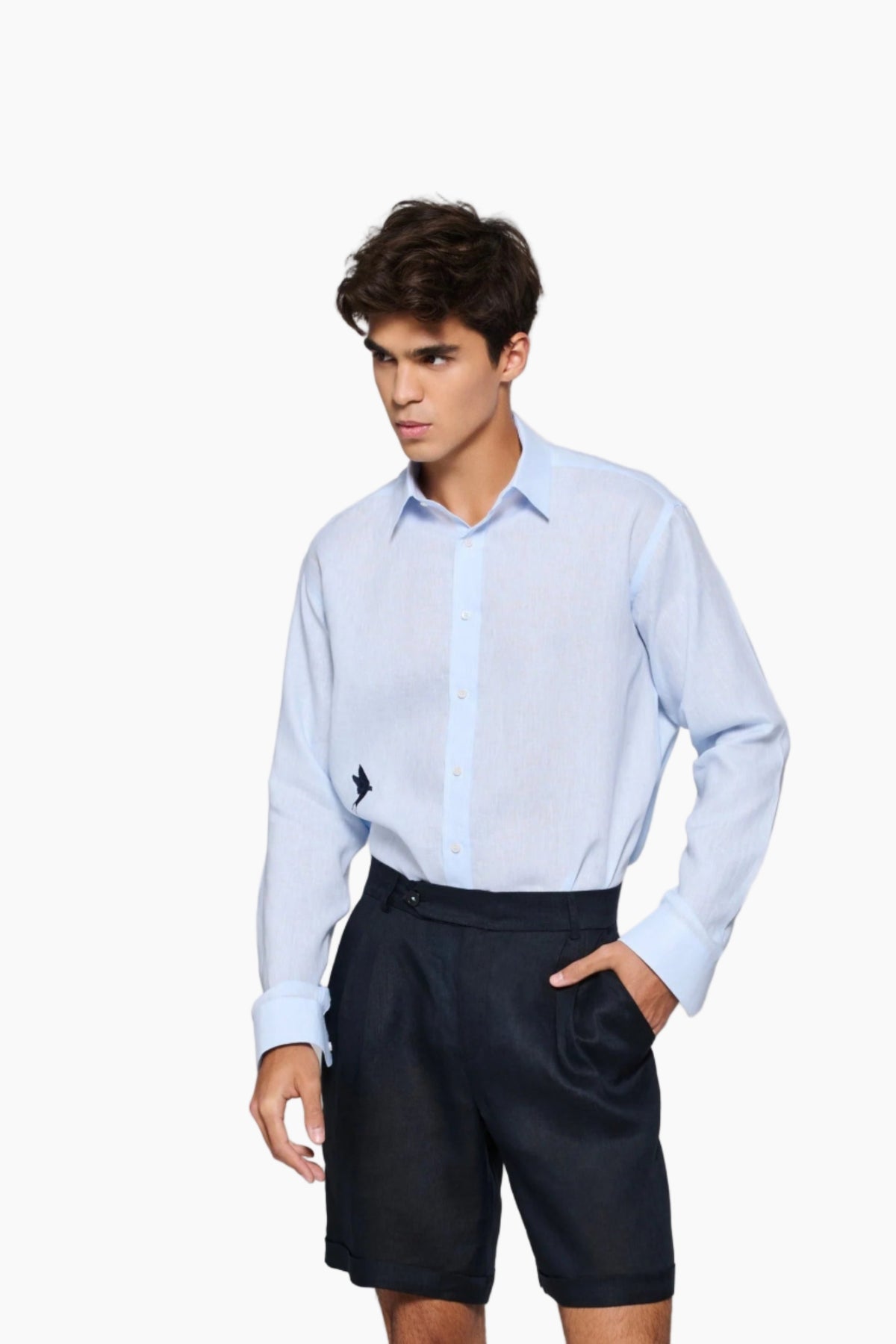 Man wearing a Man wearing a light blue shirt and black shorts : Tailored fit baby blue 100% fine Linen men shirt with a hanging two love birds and a sunset view embroidery on the chest.