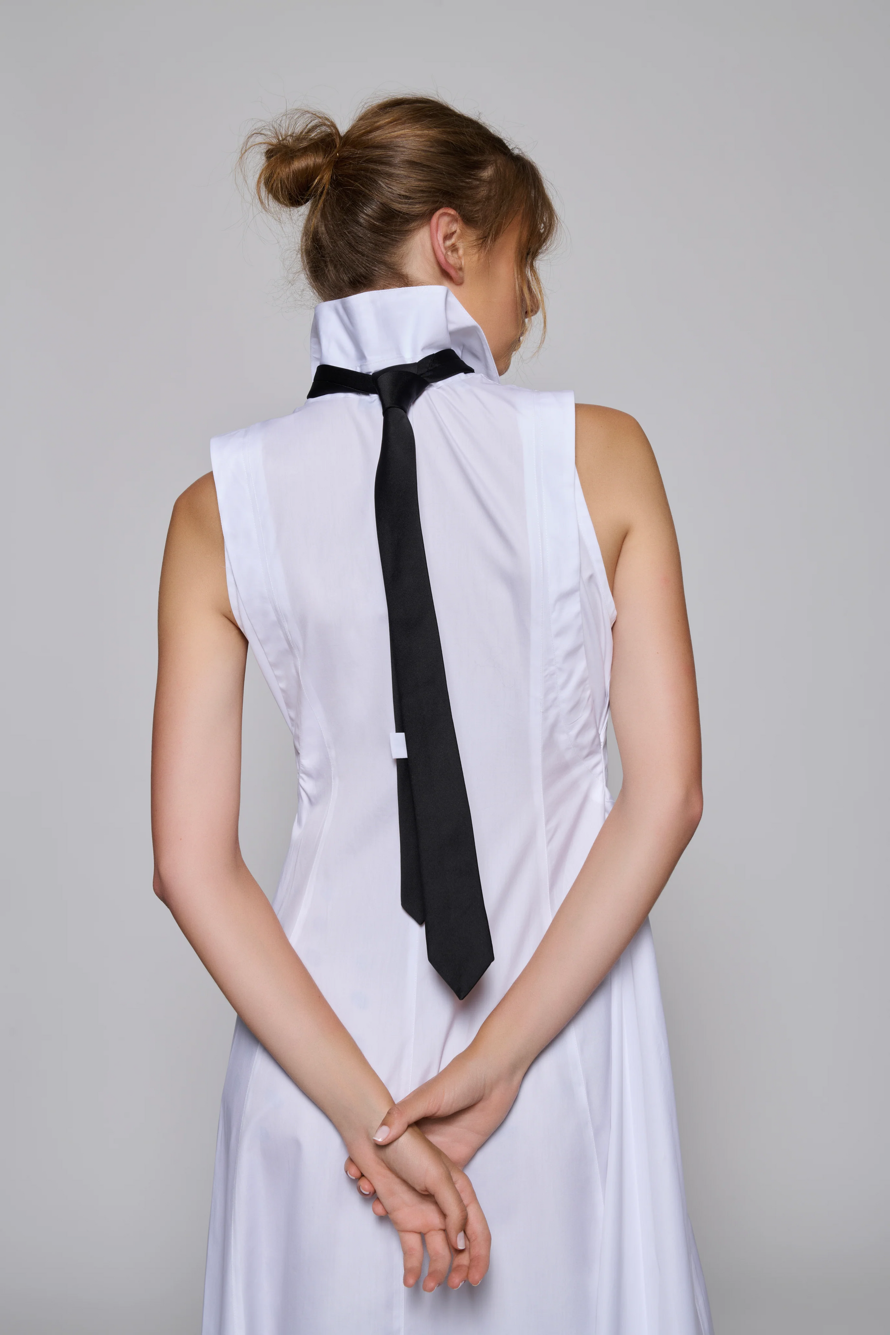 A long buttoned up White Poplin dress with drapes on the waist and long collars adjustable in wearing methods. (Can be buckled up or left loose)
The dress has a detachable black tie on the collar and tucked on the back side of the garment.
