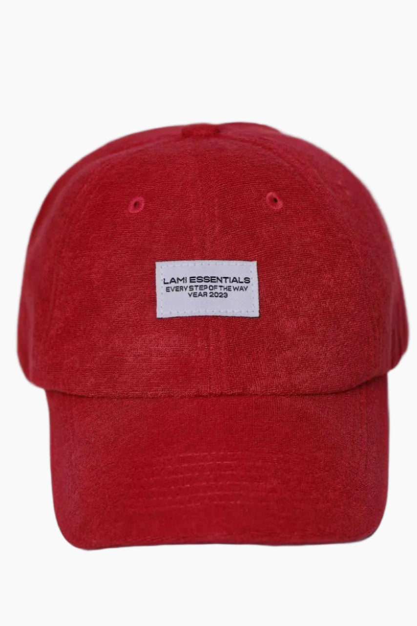 Red cap with a white label " Lami essentials"