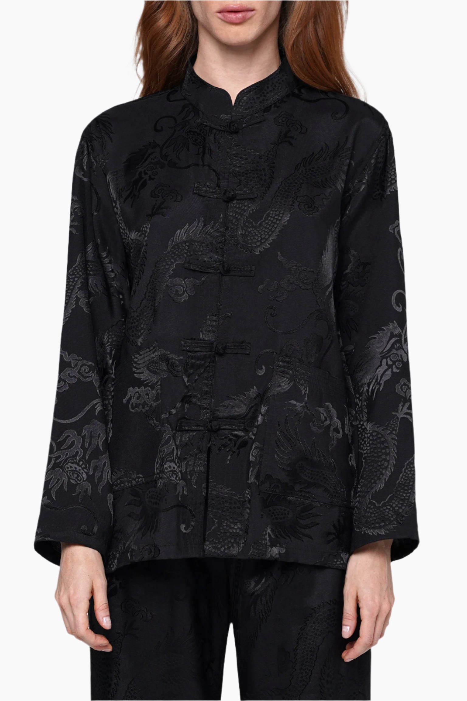 Black brocade jacket with intricate patterns worn by a person