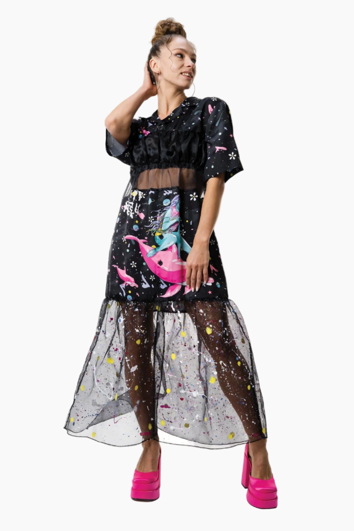 Woman wearing a black crop top and a skirt dress with colorful designs with a mesh covering