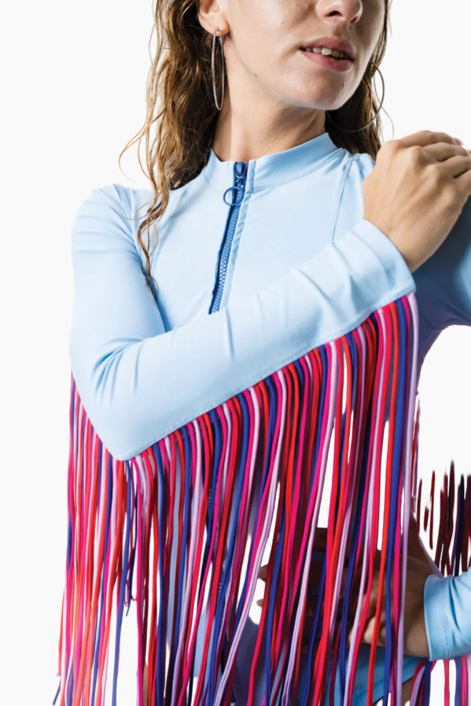 Model wearing a blue bodysuit with pink fringe