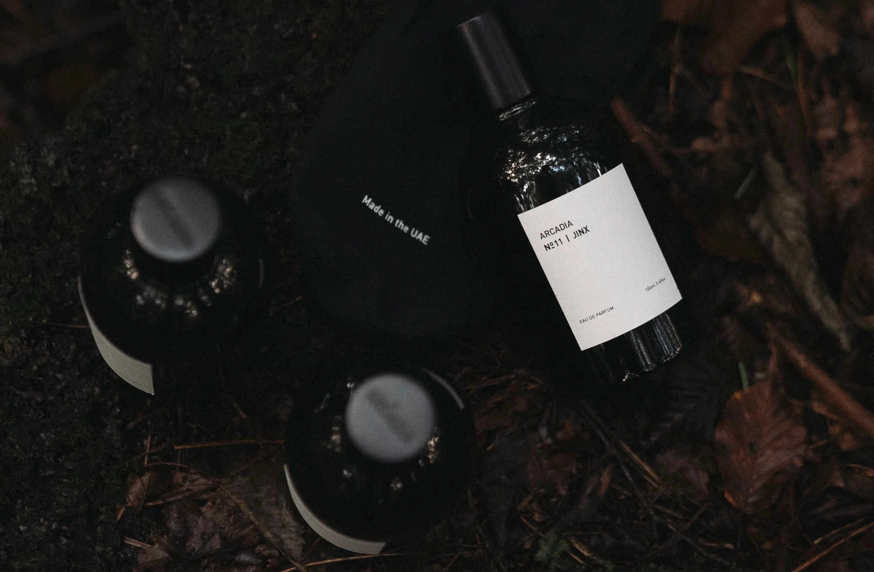 Brown bottle with a label on a white background, surrounded by nature-themed images. mber, musk, incense, tonka beans, cypriol and cambodian oud.