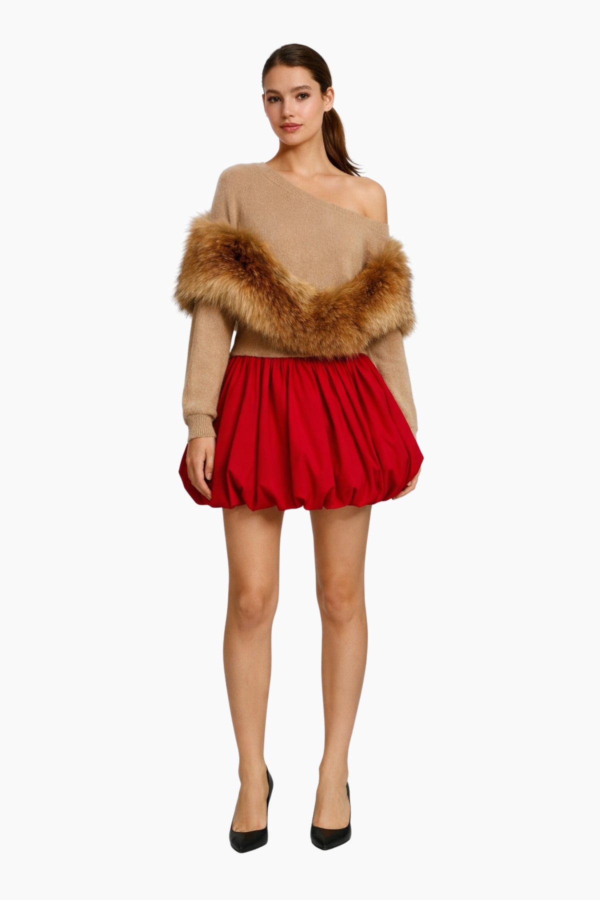 Woman wearing a beige off-shoulder top with fur trim and a red skirt on a white background