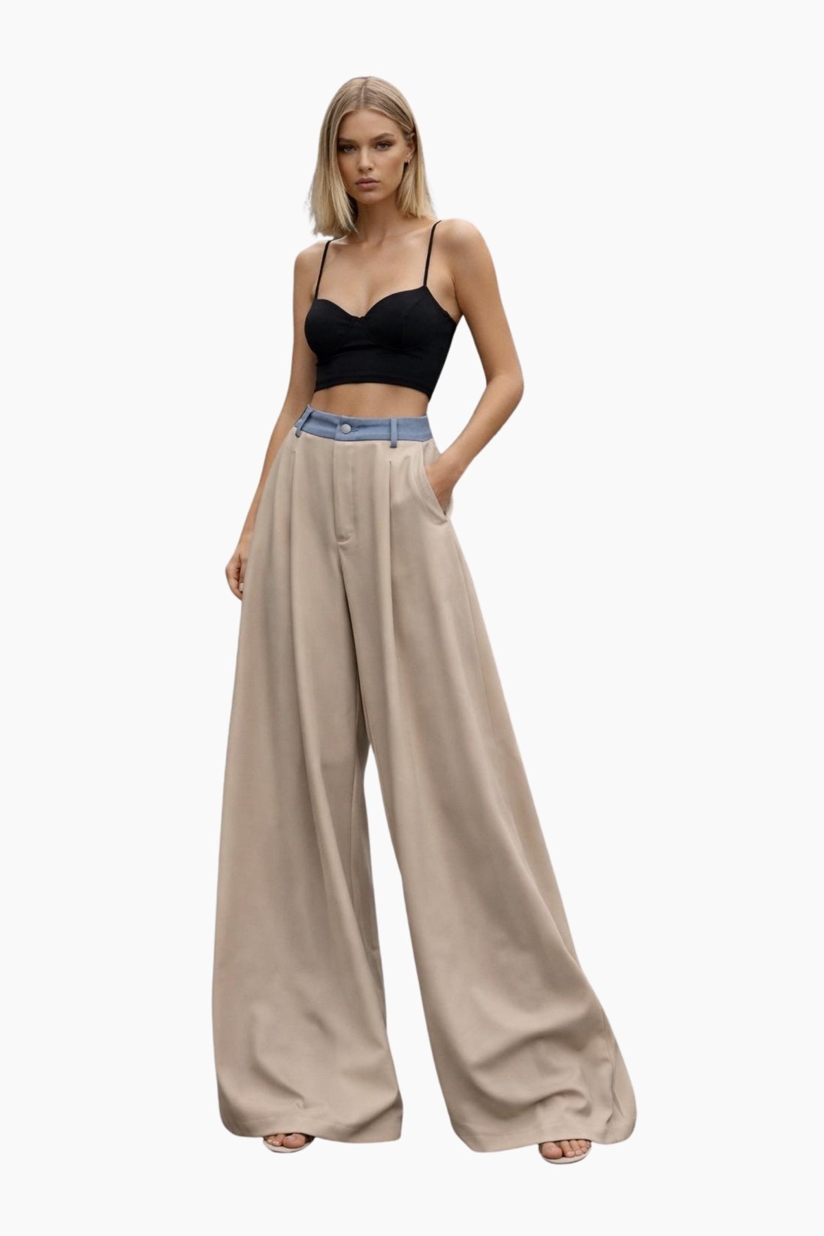Woman wearing a black top and beige wide-leg pants on a white background