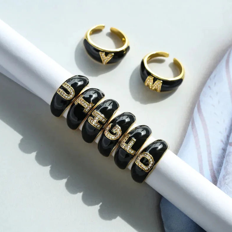 Black and gold rings with lettering on a white surface