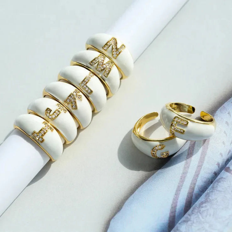 Set of gold and white rings on a light gray background