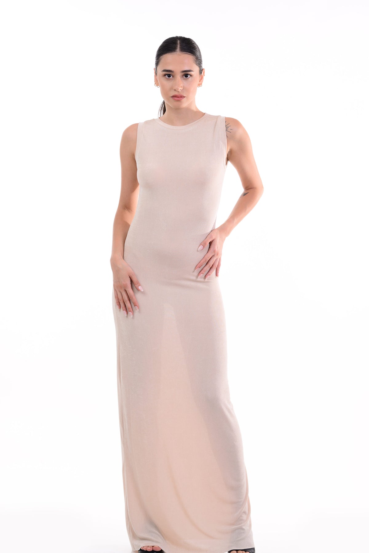 Woman wearing a long beige dress on a white background