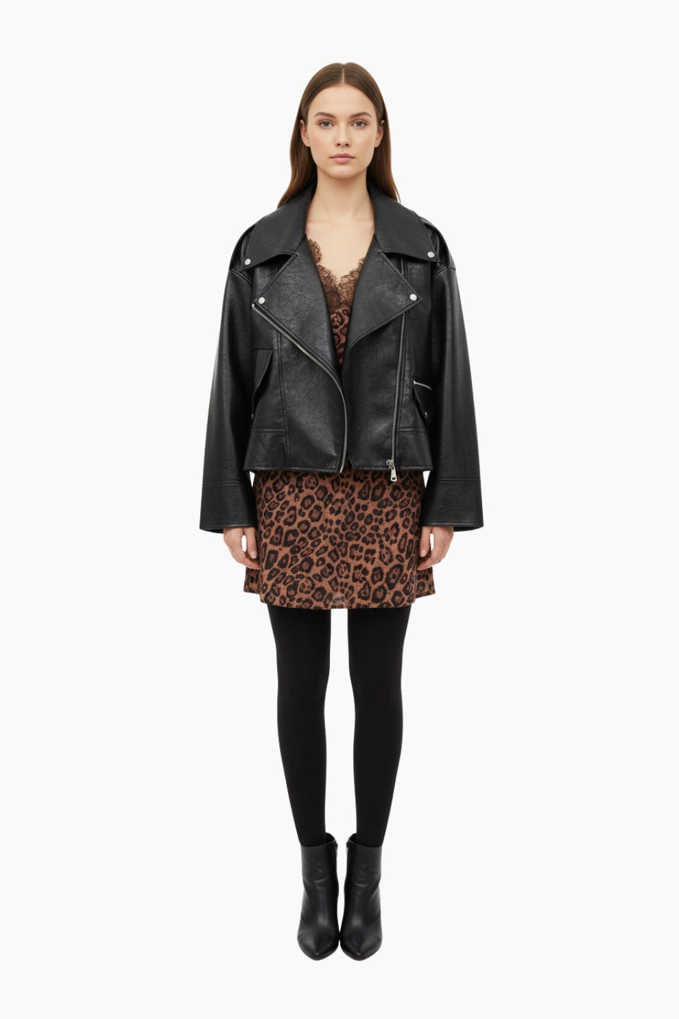 Woman wearing a black leather jacket, leopard print skirt, and black tights