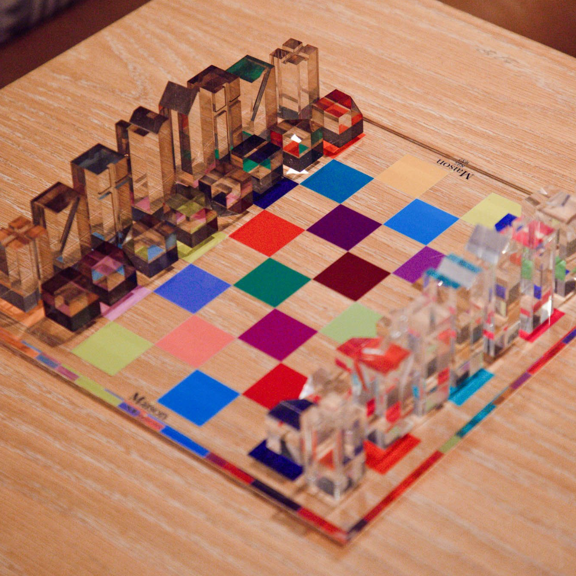 Colorful transparent building blocks on a checkered board