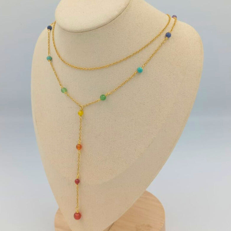Necklace with colorful beads on a mannequin bust against a light gray background