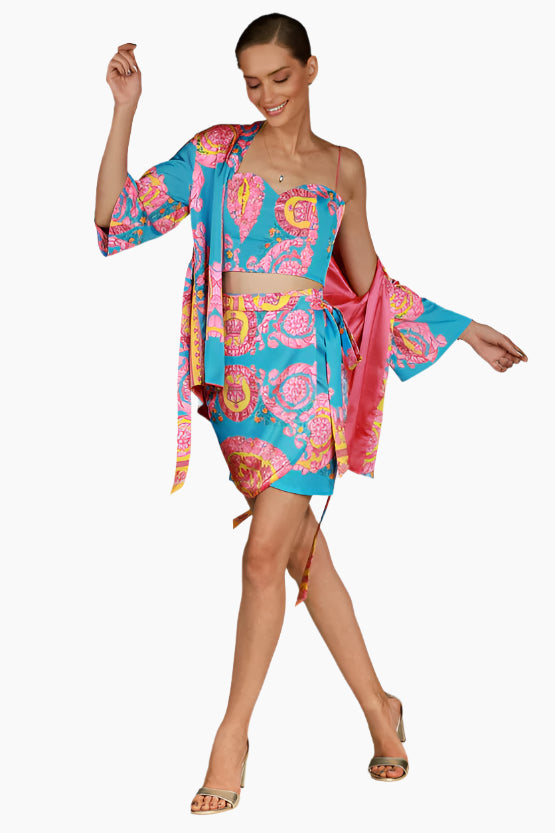 Woman wearing a colorful floral outfit skirt, top and kimono