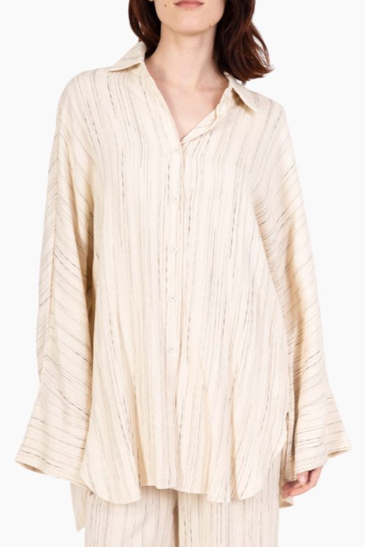 Beige textured shirt worn by a person on a white background