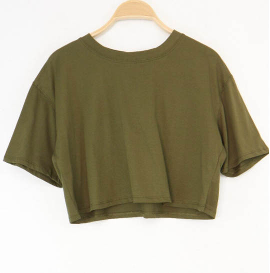 Woman wearing a black top and beige pants on a white background