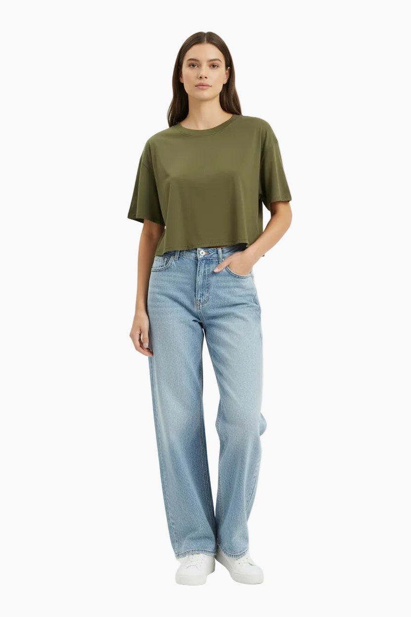 Woman wearing a black top and beige pants on a white background