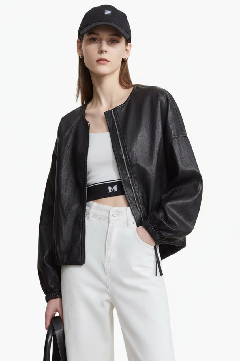 Person wearing a black leather jacket, white top, and pants