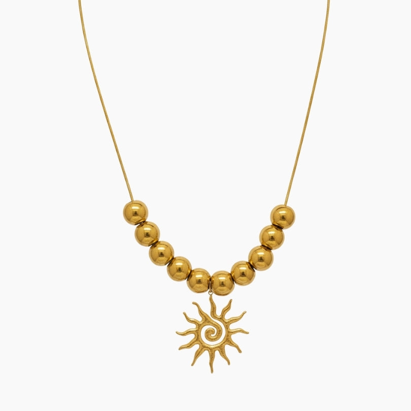 Gold dots necklace with a sun swirl in the middle