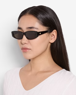 Woman wearing black sunglasses with a plain white background