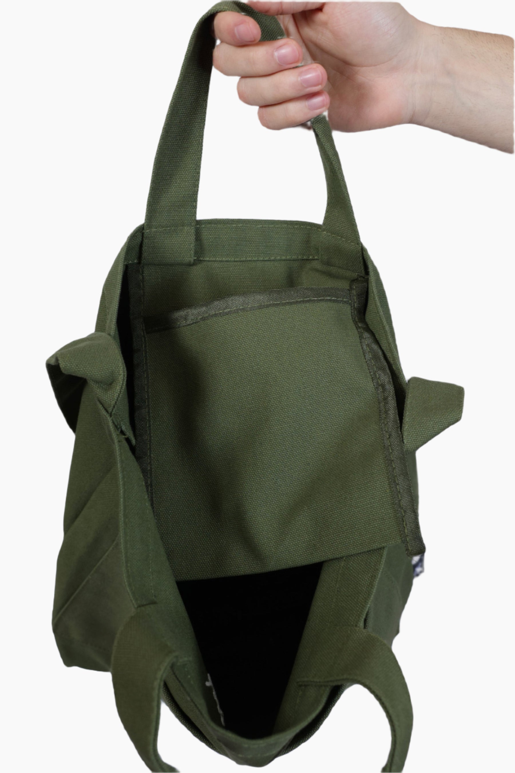 Green backpack held by a hand against a plain background