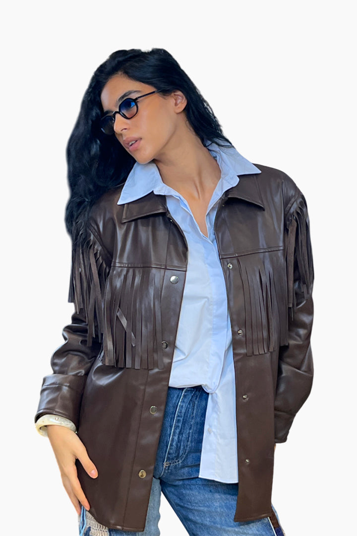 Woman wearing a brown leather jacket over a light blue shirt