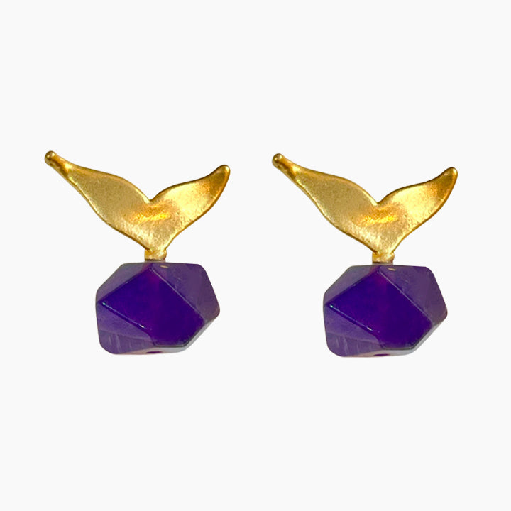 Pair of gold and purple earrings on a white background