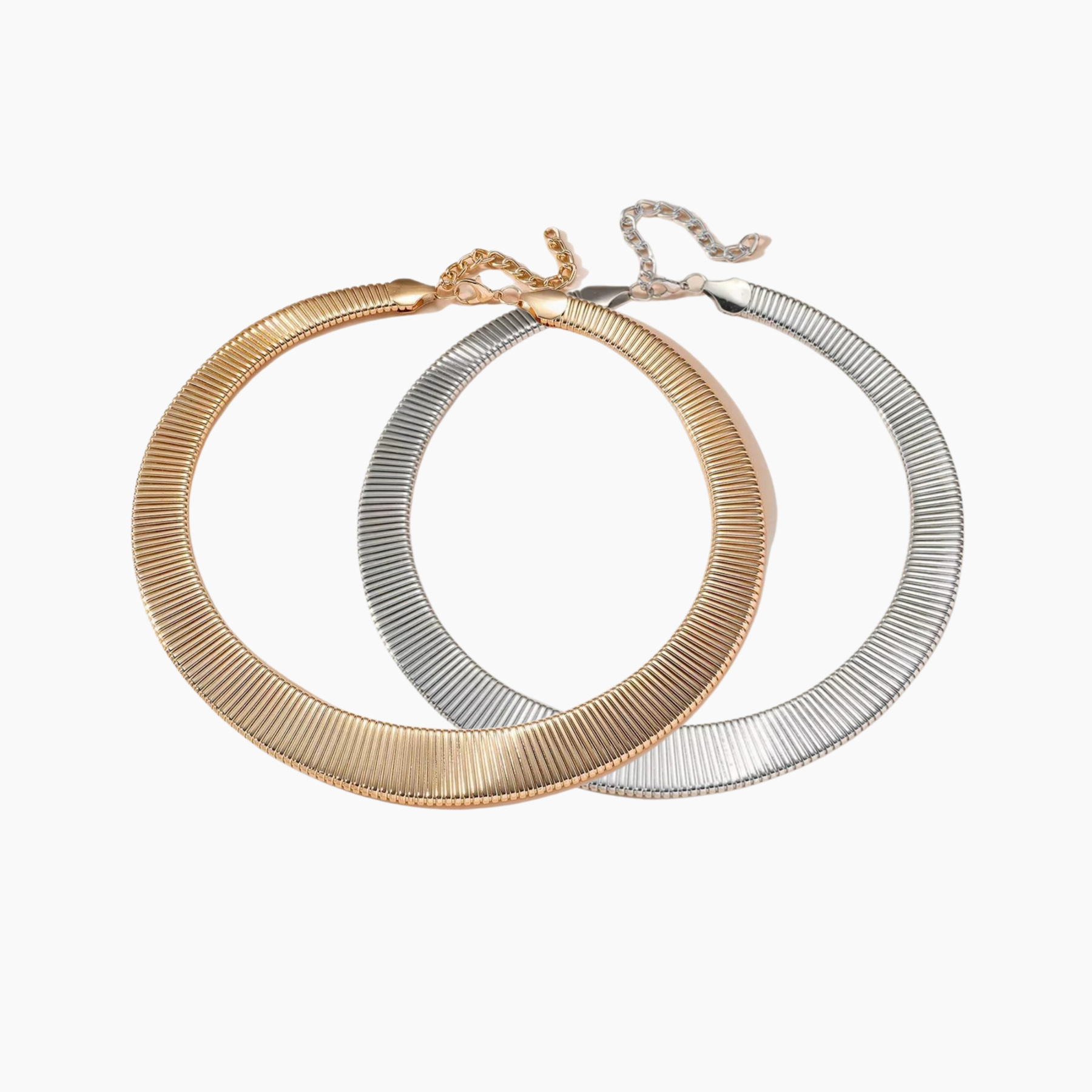 Two hoop earrings, one gold and one silver, on a white background