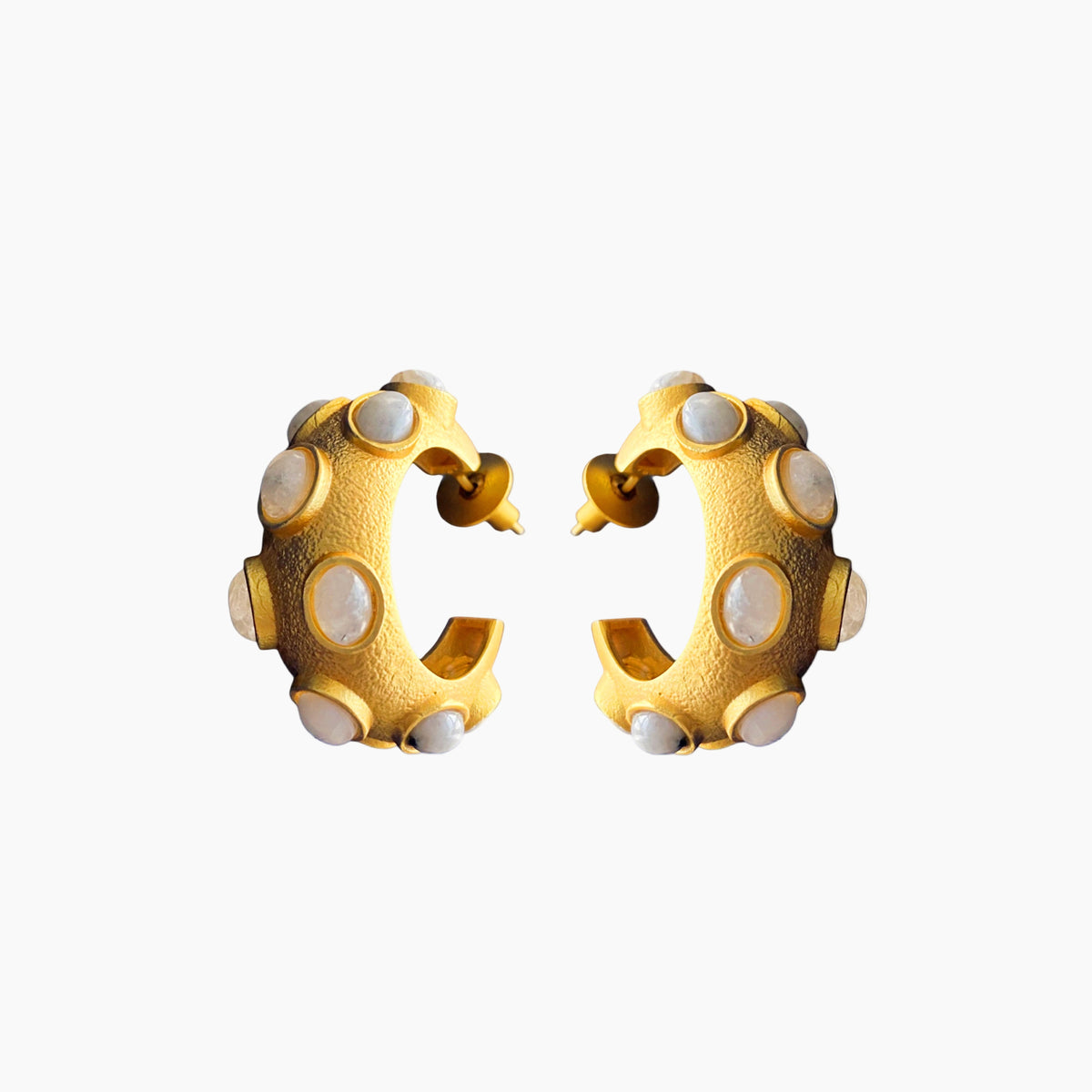 Gold hoop earrings with white circular stones on a white background