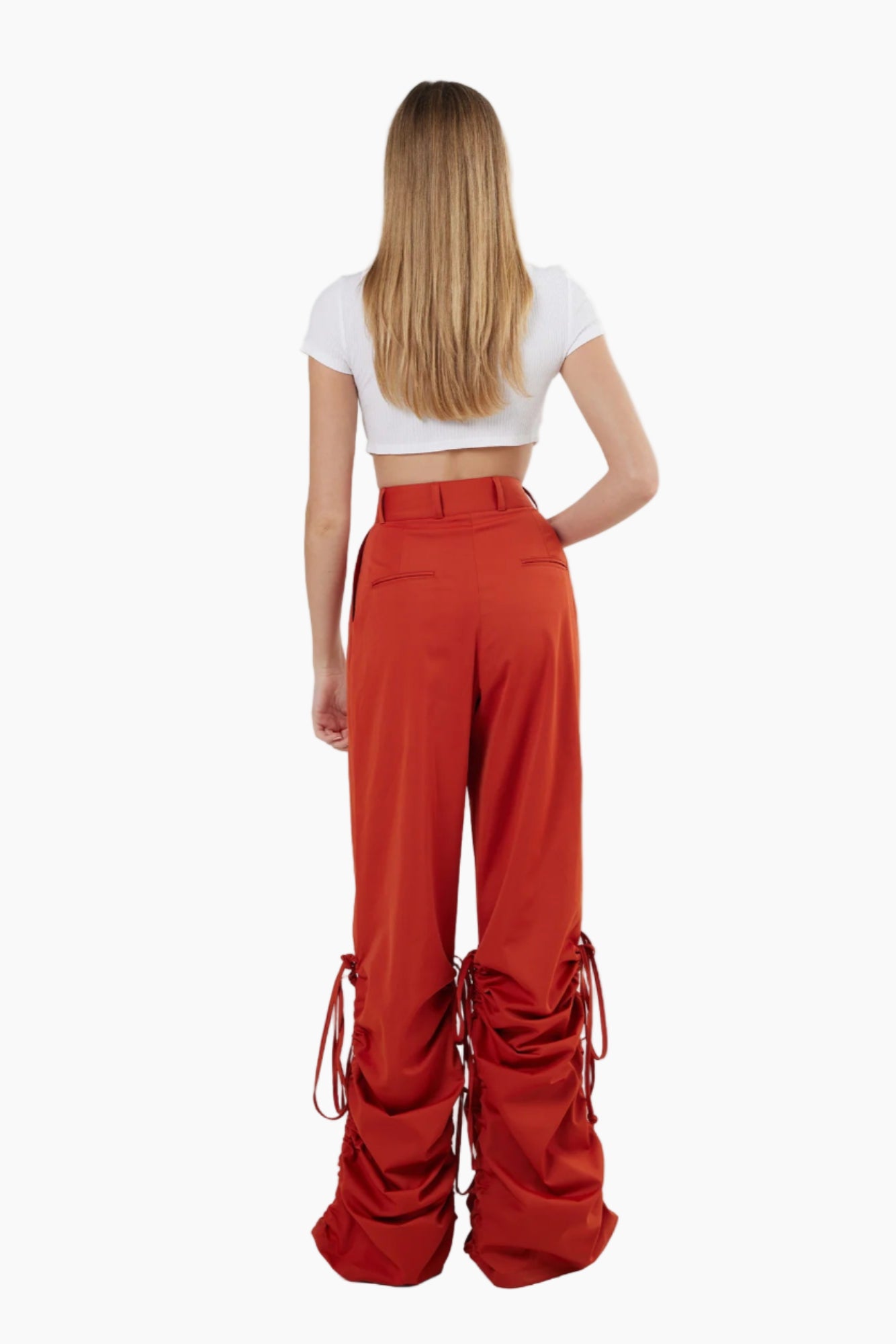 Person wearing red pants with tie details on a white background