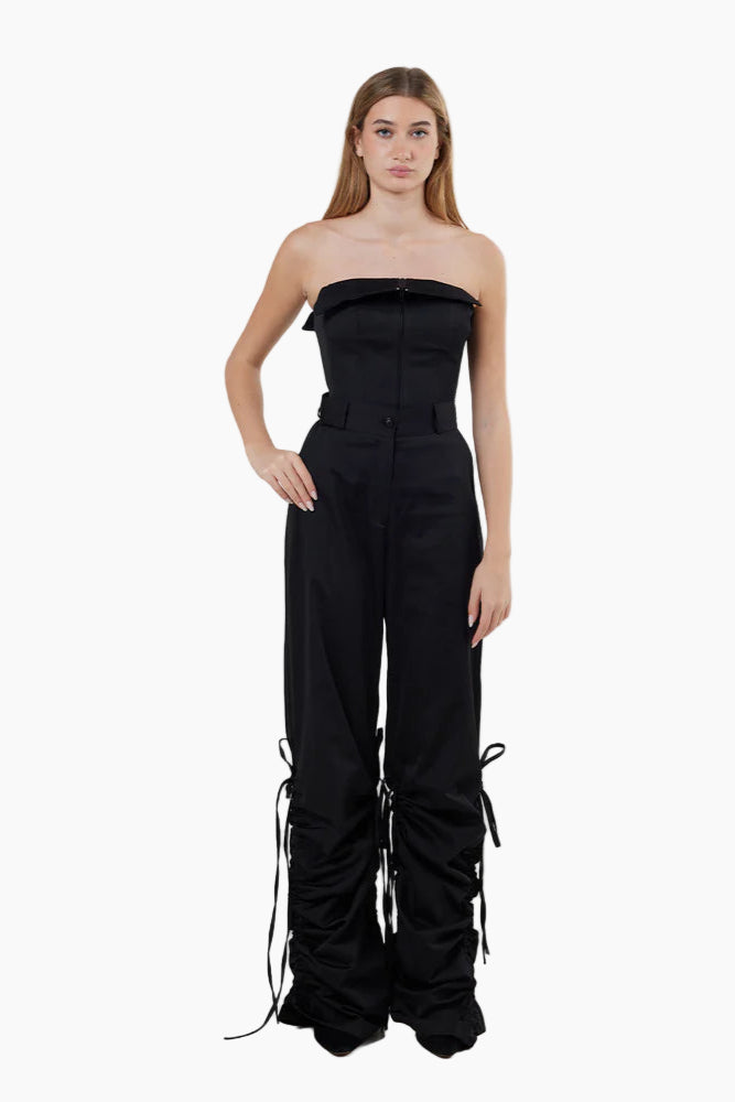 Black strapless top and pants with ruched details on a white background