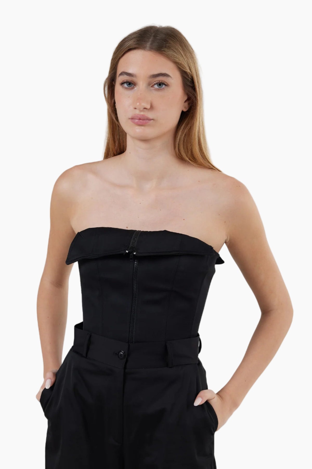 Woman wearing a black strapless outfit on a white background