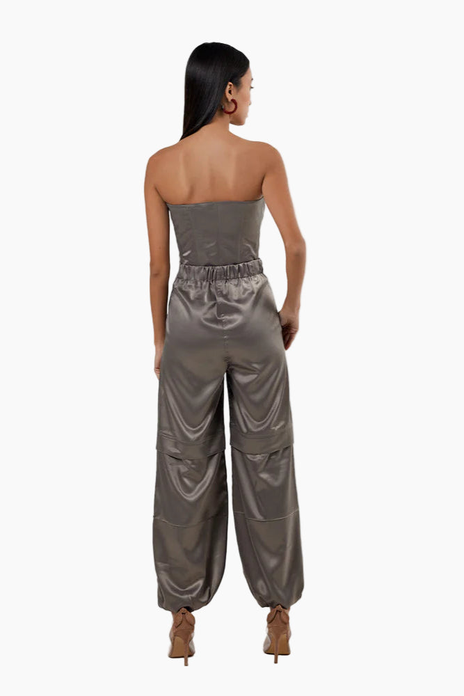 Woman wearing a strapless metallic jumpsuit on a white background