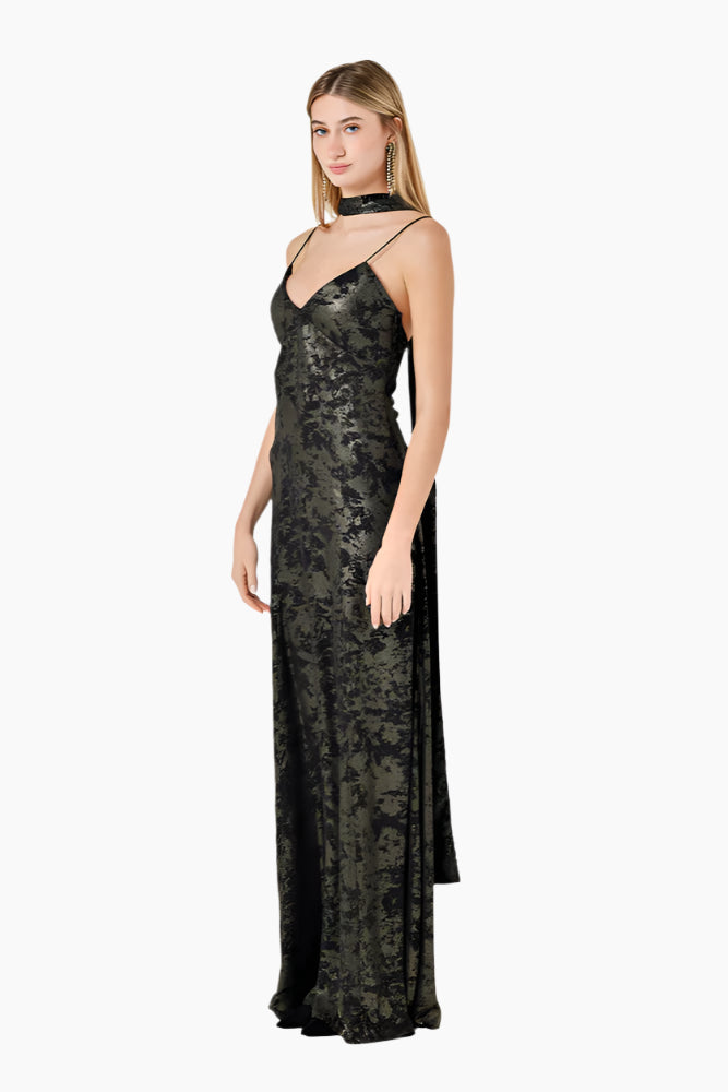 Woman wearing a black Flared floor-length dress with structured cuts and a scarf.
