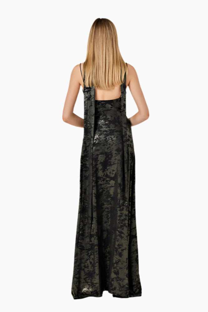 Woman wearing a black Flared floor-length dress with structured cuts and a scarf.