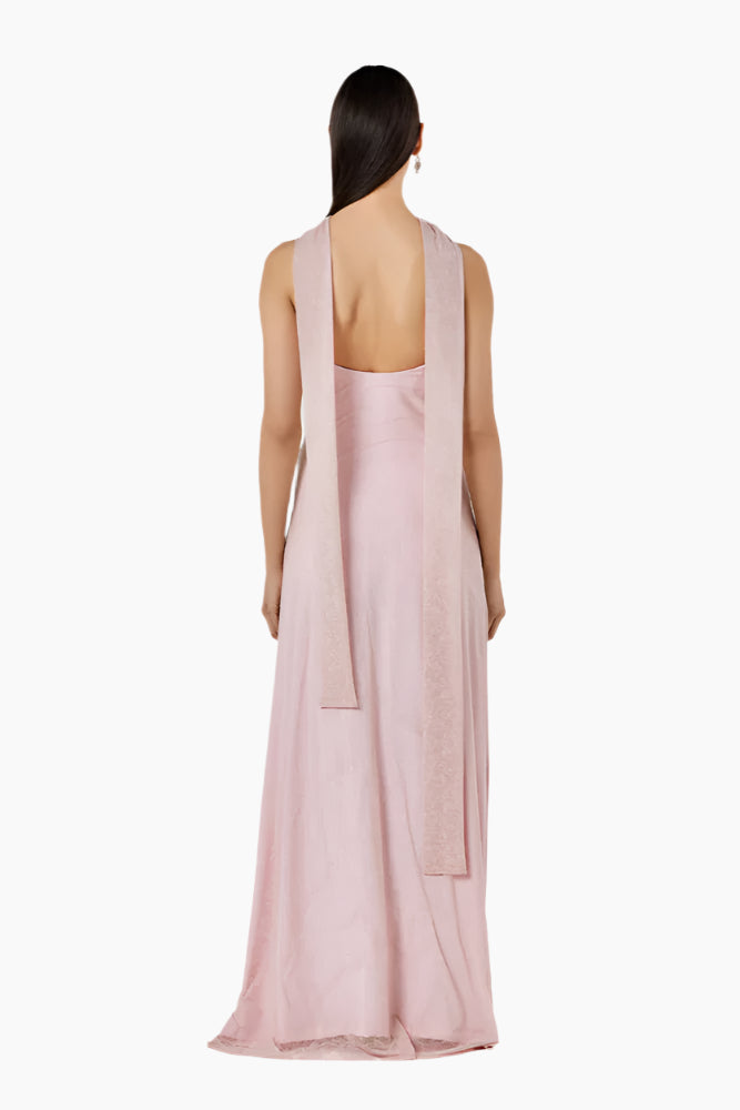 Woman wearing a light pink sleeveless dress with a backless design