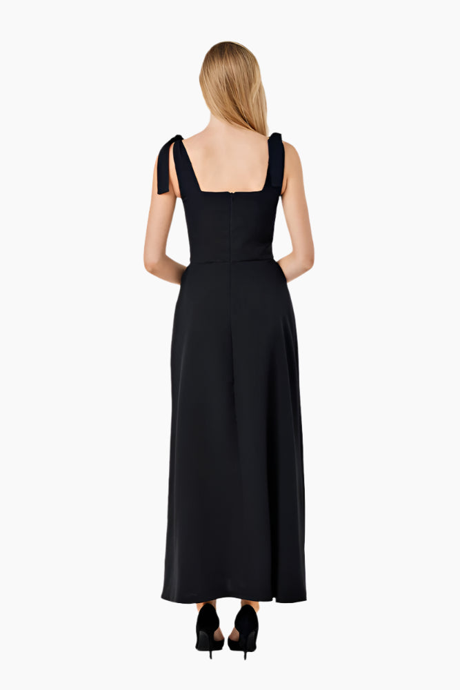 Woman wearing a black lace dress Fitted corset-like ankle-length dress with adjustable straps, a flared skirt, and a middle back zipper.