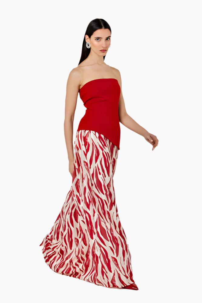 Woman wearing a strapless red dress with a zebra print skirt. Strapless top with an asymmetrical hem and a side zipper. Styled with a gathered skirt with a waistband and invisible zip fastening.