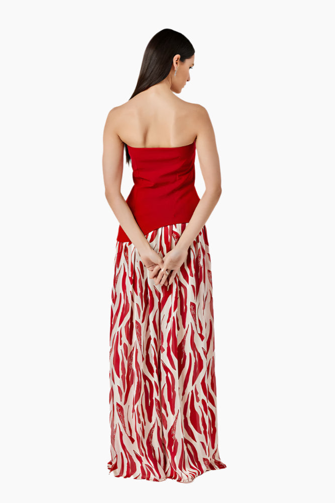 Woman wearing a strapless red dress with a zebra print skirt. Strapless top with an asymmetrical hem and a side zipper. Styled with a gathered skirt with a waistband and invisible zip fastening.
