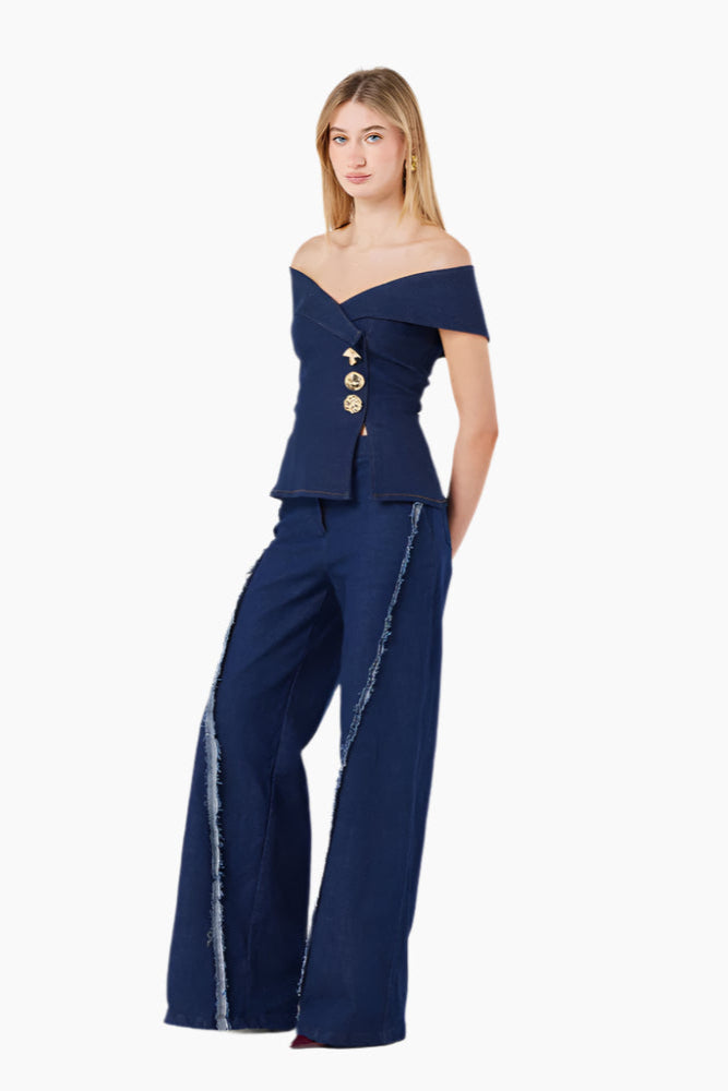 Woman wearing a navy blue off-shoulder top with buttons and wide-leg pants